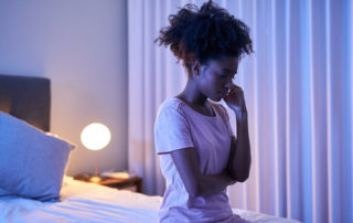 Cropped shot of a young woman sitting alone in her bedroom