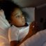 Child using tablet in bed when they should be asleep.