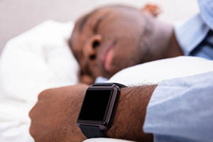 actigraphy - man sleeping with smart watch