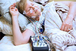 multiple sleep latency test - woman in hospital bed hooked to sensors