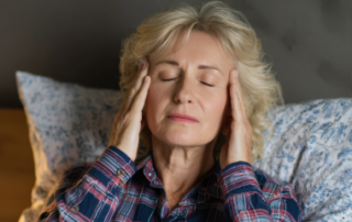 Tired woman in bed with headache